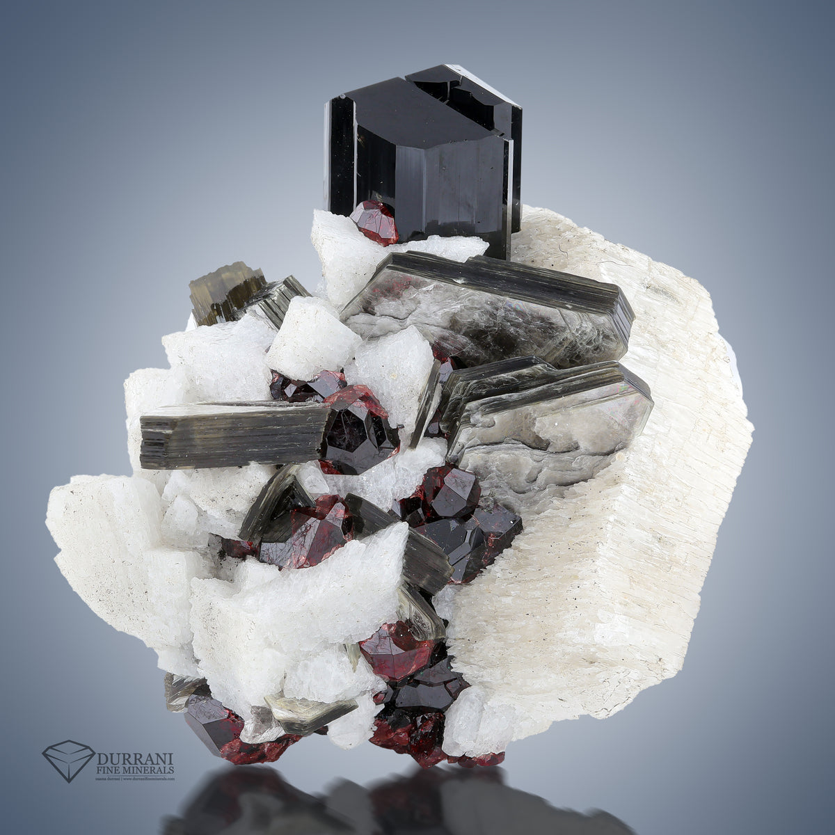 Interesting combination of Spessertine Garnet with Mica Feldspar and lustrous Schrool.